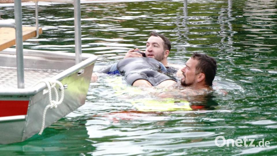 Eine schwimmende Trage wird unter die zu rettende Person geschoben, was auch der Übung bedarf. Bild: bkr
