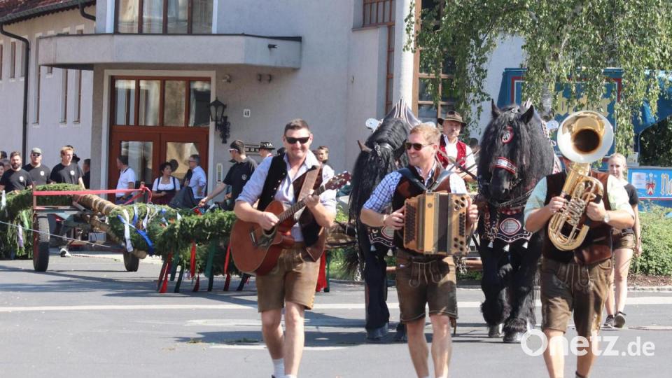 Mit einem feierlichen Umzug mit Musik wird der Baum zum Dorfplatz gebracht. Bild: mfh