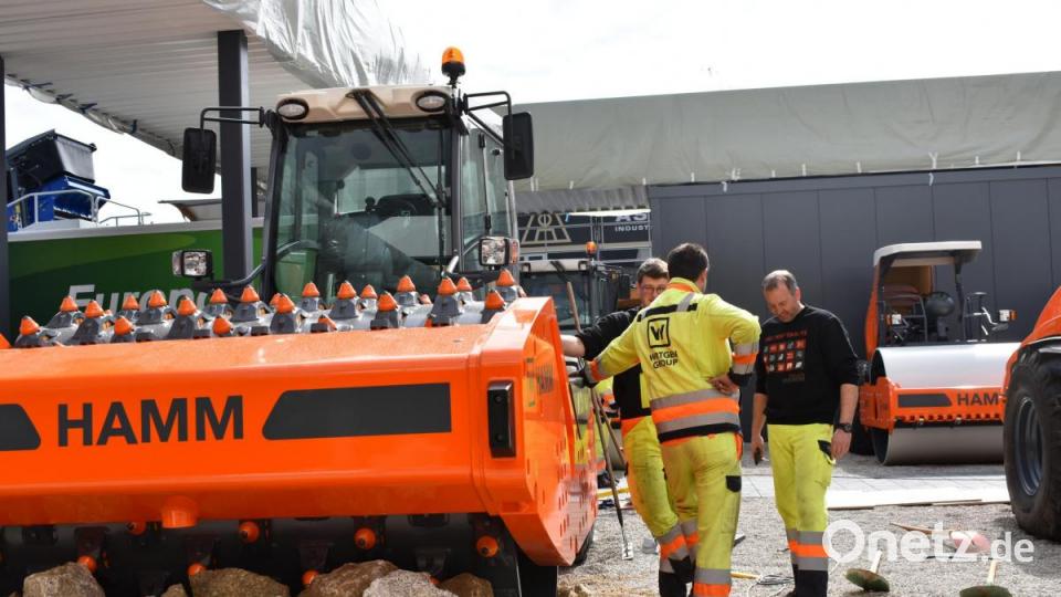 Nach der Übernahme der Wirtgen Group durch &quot;Deer &amp; Company&quot; will Hamm auch vermehrt in den Erdbau einsteigen. Diese Walze, die ganze Gesteinsbrocken zertrümmern kann, soll dass demonstrieren. Mitarbeiter der Hamm AG sortieren Granit aus Dippersreuth um die Baumaschine. Bild: lue