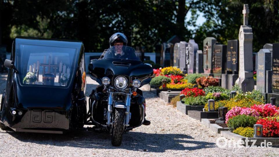 Bestatter Wolfgang Frisch fährt mit seinem Bestattungsmotorrad, einer umgebauten Harley-Davidson, über einen Friedhof. Bild: Sven Hoppe/dpa