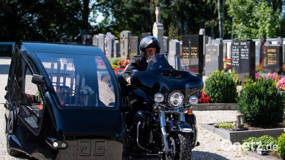 Bestatter Wolfgang Frisch fährt mit seinem Bestattungsmotorrad, einer umgebauten Harley-Davidson, über einen Friedhof. Bild: Sven Hoppe/dpa