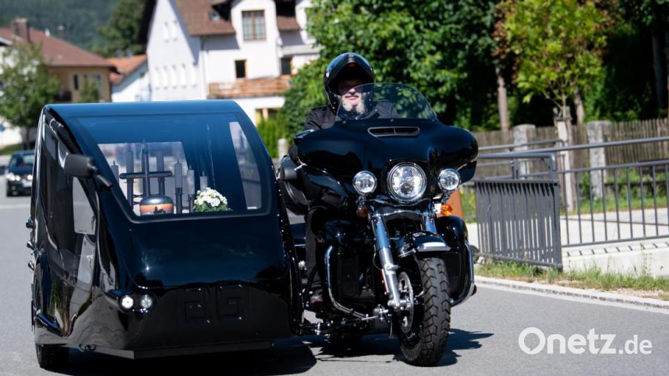 Bestatter Wolfgang Frisch fährt mit seinem Bestattungsmotorrad, einer umgebauten Harley-Davidson, über einen Friedhof. Bild: Sven Hoppe/dpa