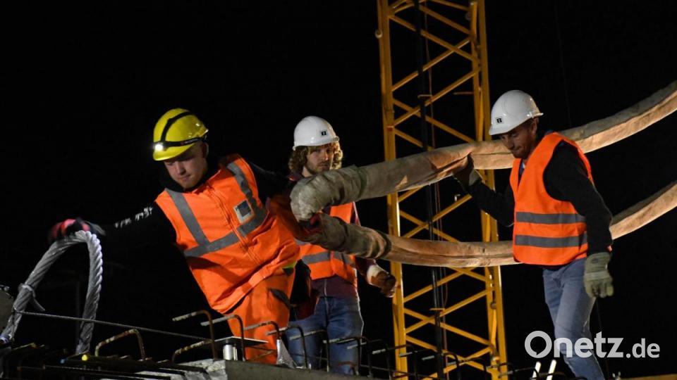Mit vereinten Kräften wurde das erste Verbindungsstück gesichert und zum Verbringen vorbereitet. Rund 30 Arbeiter waren vor Ort, um das Betonelement an Ort und Stelle zu bringen. Bild: Freya Stöckl