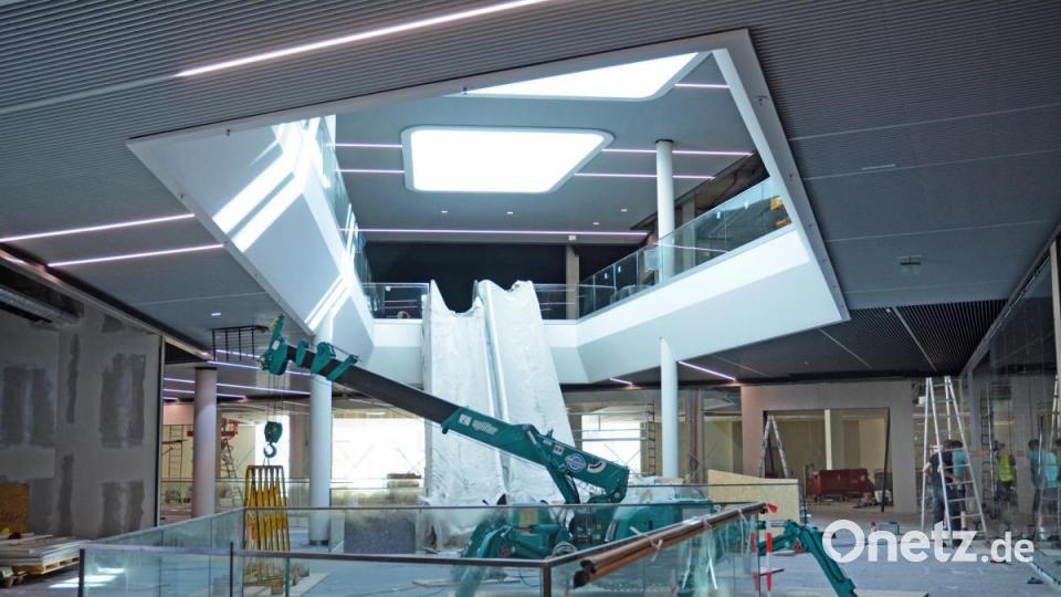 Der Blick ins Atrium beeindruckt. Glastafeln stehen für den weiteren Innenausbau bereit. Die Rolltreppen sind zum Schutz eingepackt. Bild: Gabi Schönberger