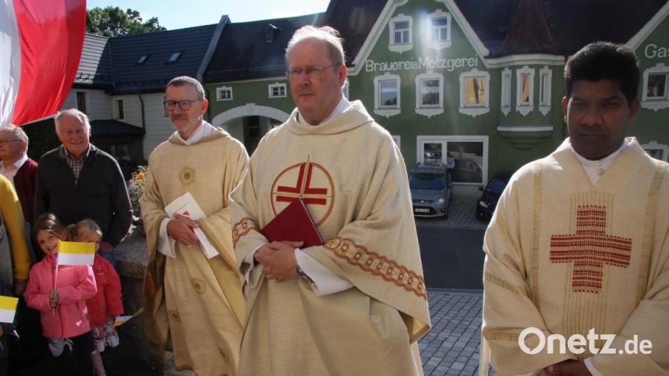 An den Kirchenstufen wurde der neue Pfarrer von den Gläubigen gestoppt, um ihn dann in die Kirche zu begleiten. Im Bild (von rechts) Pater und Pfarrvikar Charles John, Markus Nees und Dekan Thomas Vogl. Bild: wro