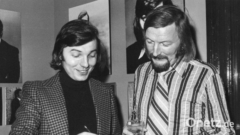 Sänger Karel Gott (l) gibt dem Bandleader James Last bei der Eröffnung des neuen Hauses der Deutschen Grammophon ein Autogramm. Bild: Lothar Heidtmann/dpa