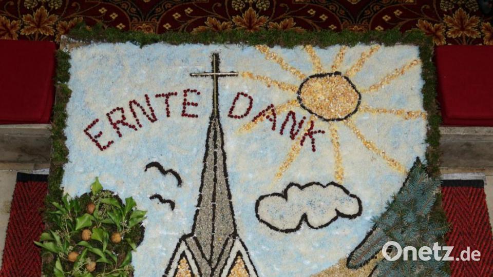 Außergewöhnlich ist der Erntedankaltar anlässlich der Erhöhung des neu sanierten Kreuzes auf der Kirchturmspitze der Pfarrkirche St. Margareta im Rahmen der Kirchturmrenovierung ausgefallen. Die Verantwortlichen aus der Kemnather Pfarrei haben einen Körnerteppich mit dem neu gestalteten Kirchturm zum Erntedankfest vor dem Altar gelegt. Bild: ads