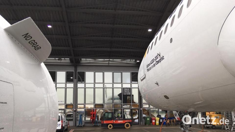 Ungewöhnliche Perspektive: Dieses Foto des neuen Airbus A320-200 &quot;Weiden in der Oberpfalz&quot; entstand unterhalb der linken Tragfläche zwischen Triebwerk und Rumpf. Auf den Fenstern des Hangars in Hamburg-Finkenwerder ist das Spiegelbild der Maschine zu sehen. Auf dem dortigen Airbus-Werksgelände ist das Flugzeug auch endmontiert worden. Bild: Lufthansa