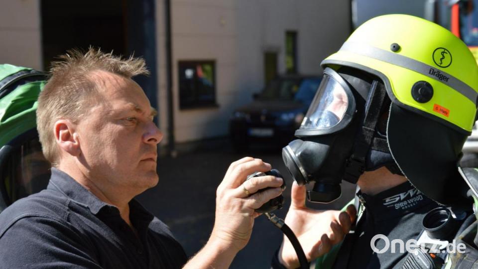 Kreisbrandmeister Alexander Graf (links), der Leiter des Fachbereiches Gefahrgut, schließt den Lungenautomaten an die Atemschutzmaske eines CSA-Trägers an. Bild: egl
