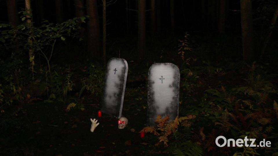 An den Grabsteinen, mitten im Wald, brennen Kerzen. Wer sie entzündet hat weiß man nicht. Bild: wro