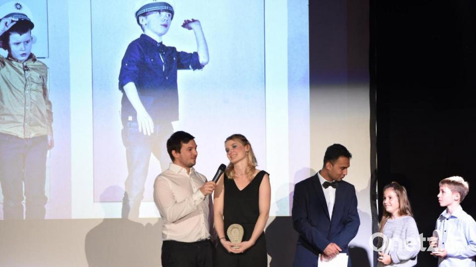 Was wäre eine Gala ohne Preise? Florian Wein (links) und Laudator Junaid Bajauri (Mitte) verleihen „Oscars“ – auch an die „spielfreudigste Familie“. Julia, Annika und Jonah Gitter (von links) wirkten in 95 Aufführungen mit. Bild: Tobias Schwarzmeier