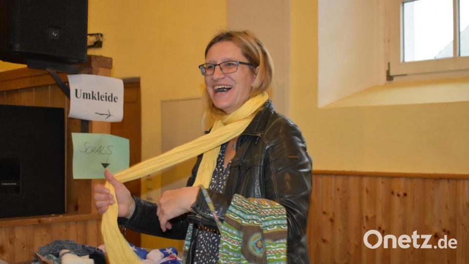 Susanne Herold findet bei der Kleidertauschparty einen gelben Schal und probiert ihn gleich an. Bild: lue
