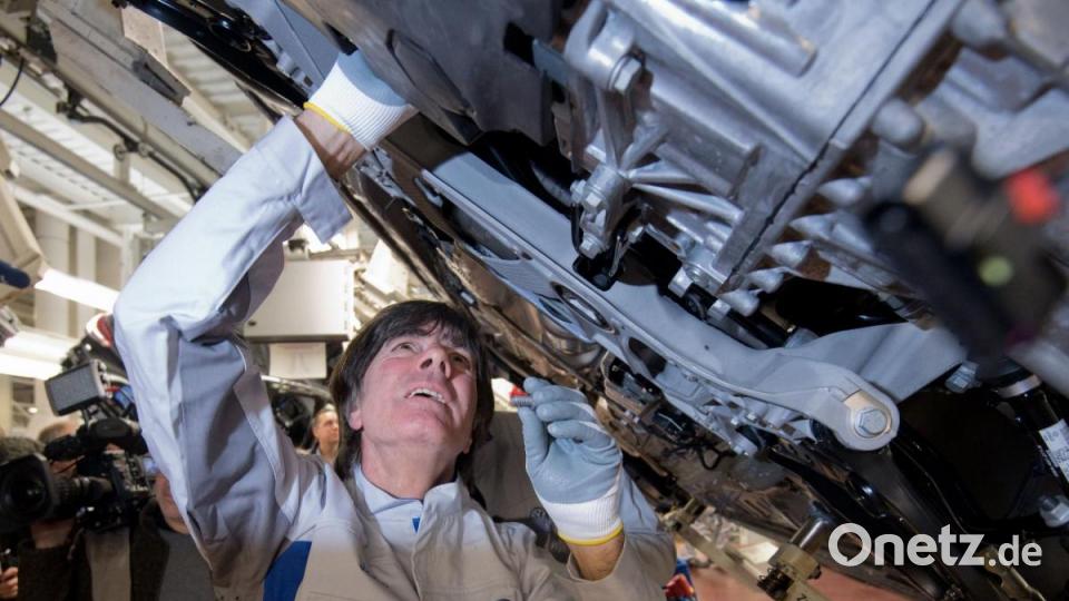 Joachim Löw, Trainer der deutschen Fußballnationalmannschaft, schraubt im VW Werk bei einem PR-Termin einen Gelenkenwellenschutz an einen neuen Volkswagen Golf 8. Bild: Julian Stratenschulte/dpa