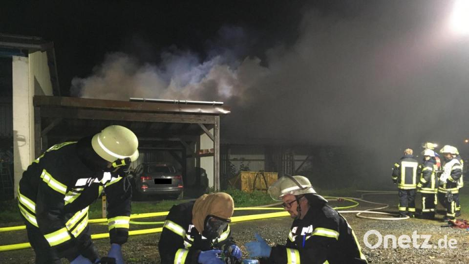 Feuerwehrleute bereiten den Atemschutz vor. Sie können verhindern, dass das Feuer auf angrenzende Gebäude übergreift. Bild: Gustl Beer