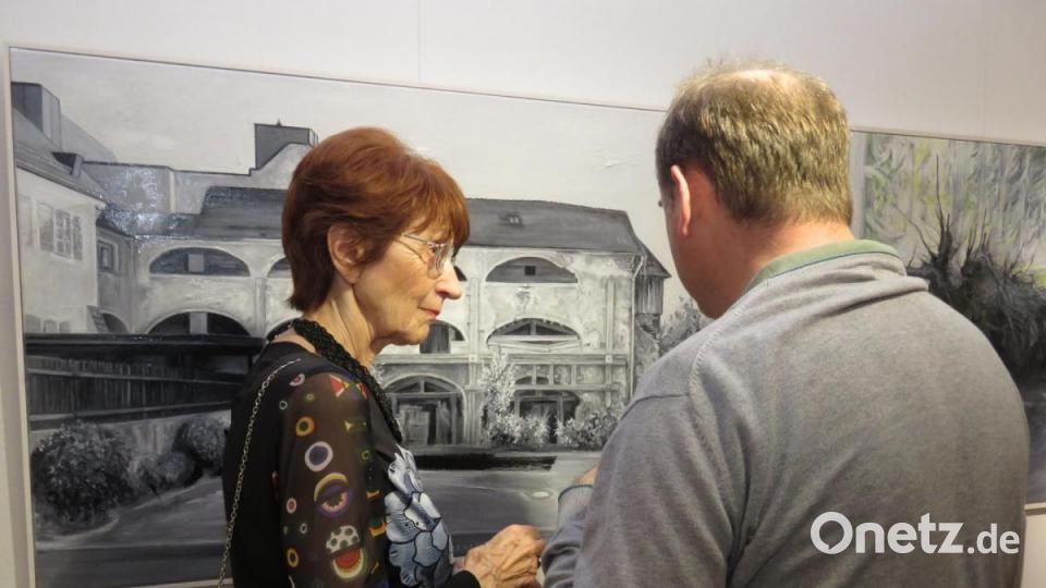 Kunst regt zum Plaudern an. Hier steht Künstlerin Margret Seer mit einem Gast vor einem Werk von Toni Eichinger. Bild: ubb