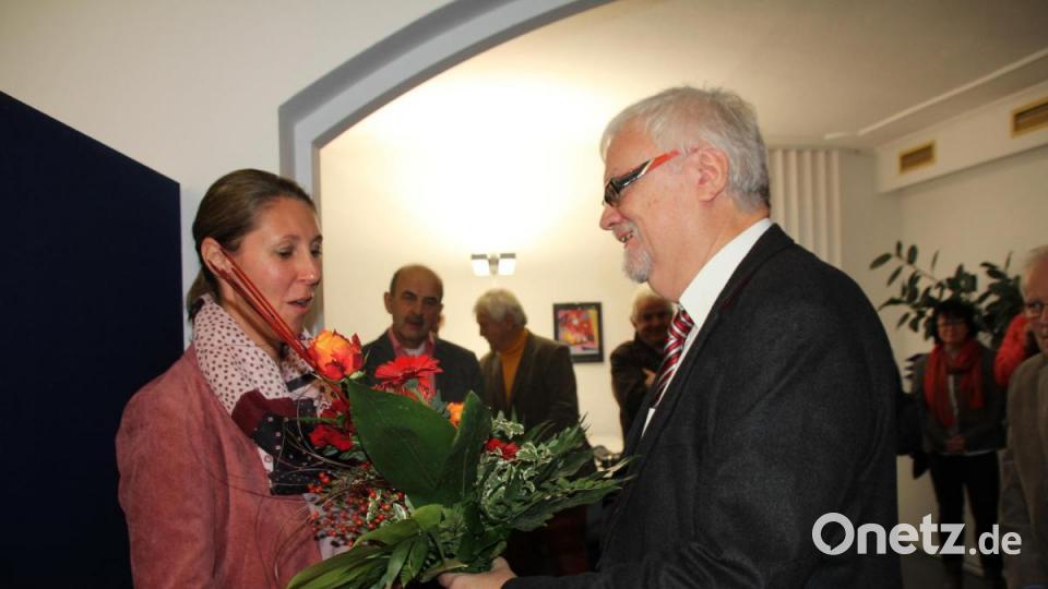 Wilhelm Amann überreicht einen Blumenstrauß an die geschäftsführende Verlegerin Viola Vogelsang-Reichl. Bild: frd