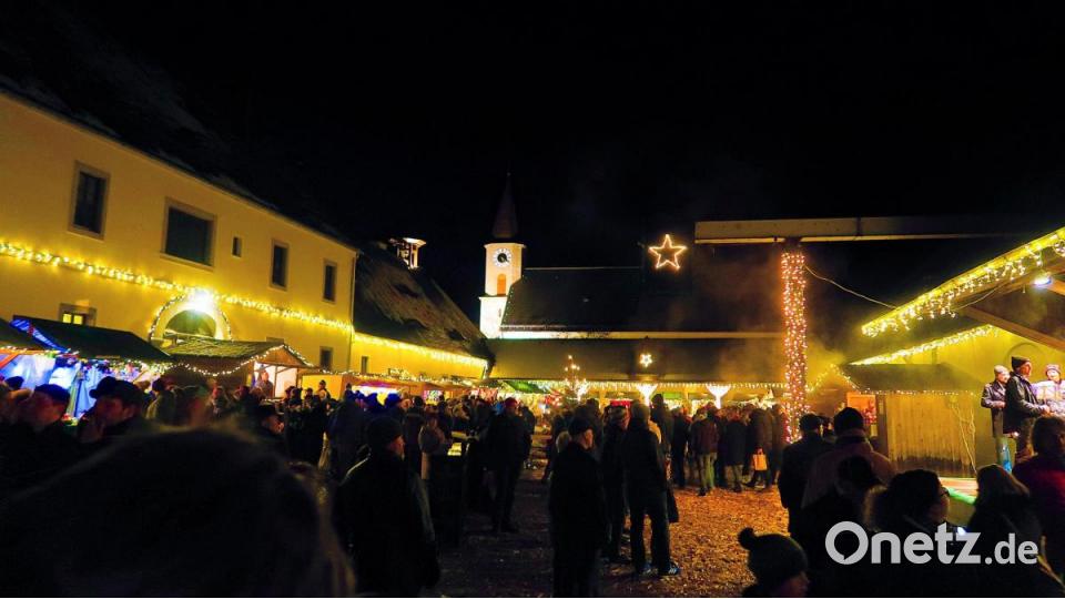 Je dunkler es wurde, desto mehr Leute bevölkerten den Weihnachtsmarkt und lauschten den Musikkapellen (rechts) auf der Bühne. Bild: bsc