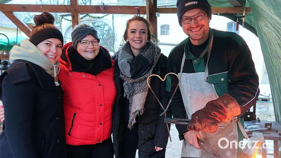 Sonderwünsche der Weihnachtsmarkt-Besucher erfüllt Schmied Uwe Heider (rechts) sehr gerne: Ein glühendes Herz für einen Verehrer war kein Problem. Die Damen waren begeistert. Bild: bsc