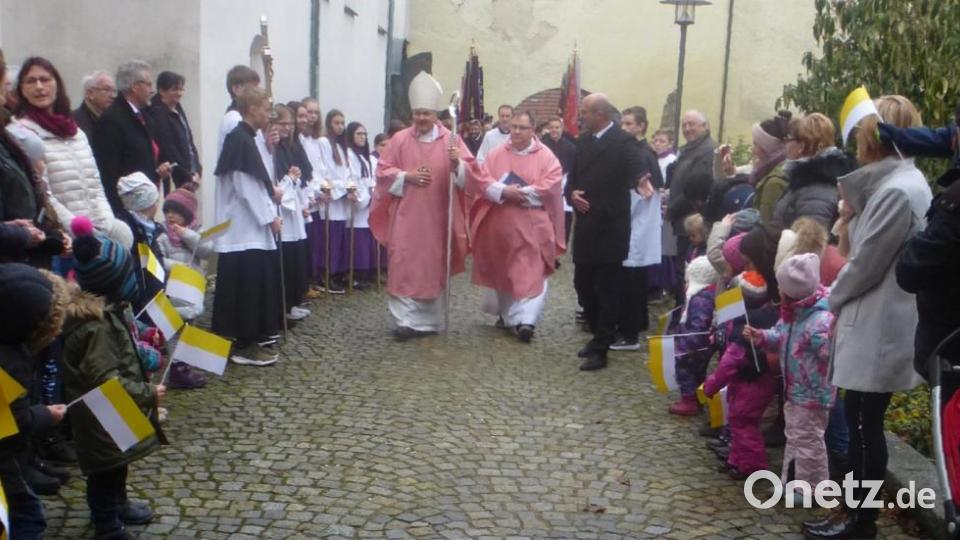 Bischof Rudolf Voderholzer und Pfarrer Markus Urban ziehen durch ein Spalier an Kindern. Bild: cv