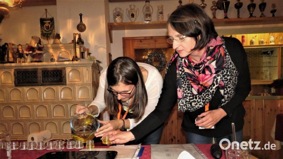 Vorsichtig füllen Anja Stock (links) und Johanna Zettl das Gemisch für die Ringelblumensalbe in die Töpfchen. Jede Teilnehmerin bekommt eines. Bild: ubb