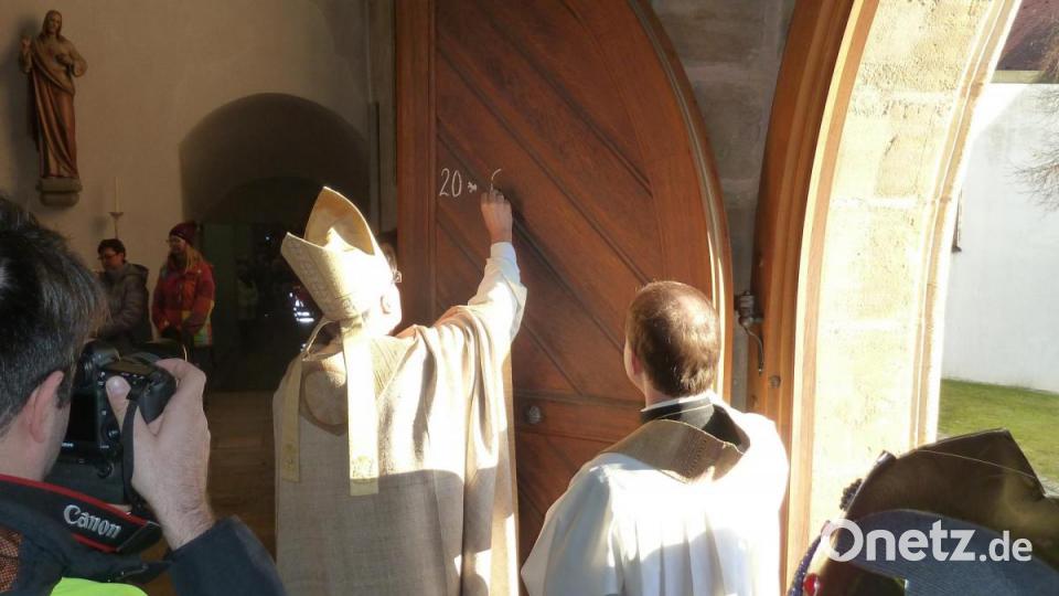 Der Bischof schreibt den Segensspruch an die Kirchentüre. Bild: Portner