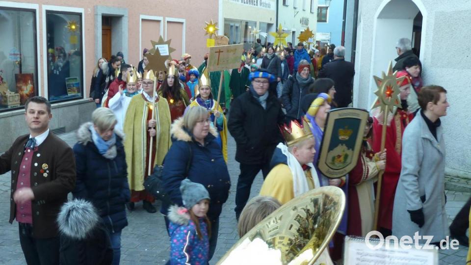 „In Harmonie vereint“ spielte die Stadtkapelle, als die 950 Sternsinger aus der gesamten Diözese durch den Rathaus-Torbogen hinauf zur Kirche zogen. Bild: Portner