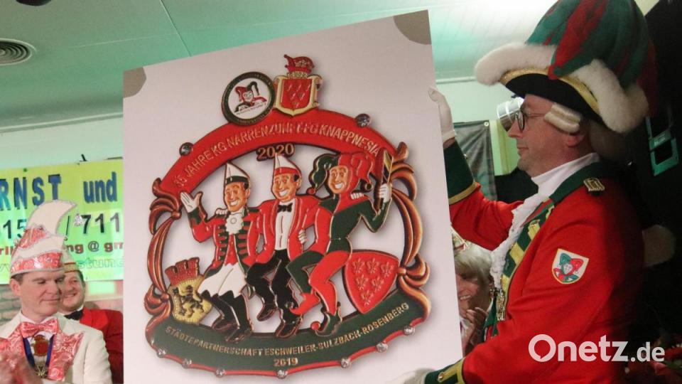 Als Gastgeschenk hatten die Freunde der Narrenzunft aus Eschweiler den Jahresorden mitgebracht, stilecht aufgedruckt auf eine riesige Tafel, so dass alle Knappnesia-Mitglieder sich geehrt fühlen. Bild: mfh