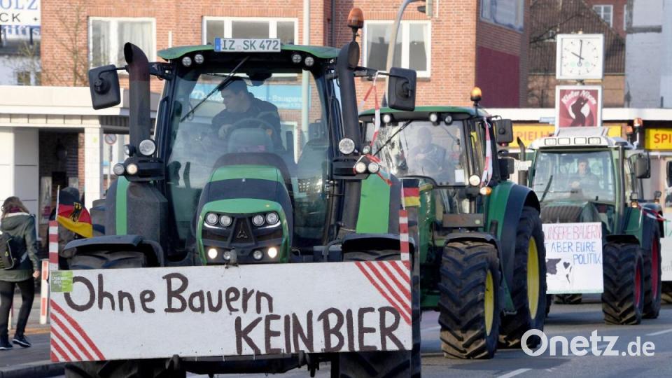 Schlagendes Argument: Landwirte nach einer Sternfahrt in Kiel. An einem Trecker warnt ein Schild mit der Aufschrift „Ohne Bauern KEIN BIER“. Foto: Carsten Rehder/dpa Bild: Carsten Rehder