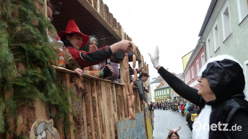 Gisela Hösl verteilte im Auftrag der Werbegemeinschaft die Knackerketten an die vorbeiziehenden 30 Gruppen. Bild: Portner
