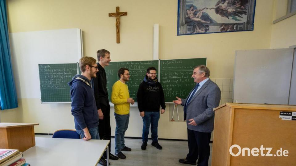 Albert Bauer, Schulleiter der Spätberufenenschule Fockenfeld, spricht mit Schülern im Klassenzimmer. Bild: Armin Weigel/dpa
