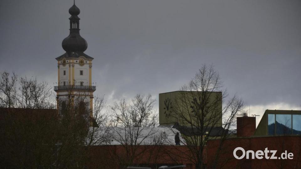 Wehrmänner suchen das Dach des Neuen Rathauses nach Schäden ab und versuchen die Schadstellen mit Folie abzudichten. Bild: Porsche