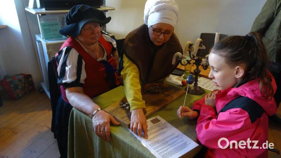 Expertinnen vom Spielekreis &quot;Tabula&quot; des Stiber-Fähnleins erklären Kindern das Radmühlespiel. Bild: hka