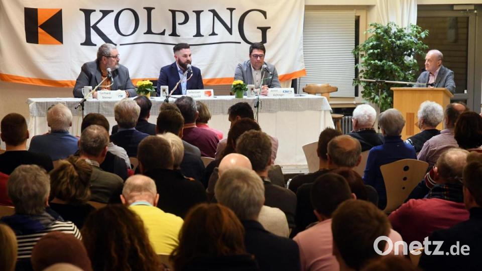 Bei der Platzverteilung ließen die Verantwortlichen der Kolpingsfamilie den Kandidaten freie Wahl. Gerhard Steiner (von links) war als erster im Pfarrheim und entschied sich für den Stuhl unter dem „K“. Als Zweiter kam Sebastian Dippold, der sich in die Mitte setzte. Für Armin Aichinger wenige Minuten später blieb der Platz unterm „G“. Martin Staffe moderierte die Podiumsdiskussion vom Stehpult aus. Bild: Gabi Schönberger