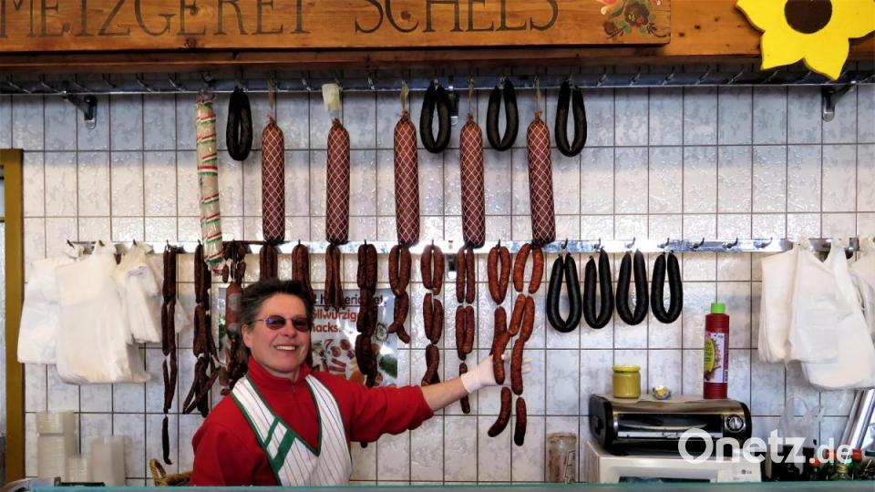 Margret Schels von der Metzgerei Schels bedient über eine höhere Verkaufstheke und mit Handschuhen ihre Kunden. Bild: ubb