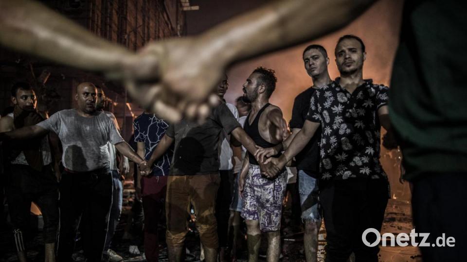 World Press Photo 2020, Kategorie &quot;SPOT NEWS - THIRD PRIZE, STORIES&quot;: Menschen stehen nach der Explosion vor dem Krebsforschungsinstituts um einen toten Körper. Mindestens 20 Menschen starben und mindestens 47 weitere wurden bei dem Terroranschlag verletzt, den die ägyptische Regierung der islamistischen Hasm-Bewegung vorwirft. Bild: Oliver Weiken