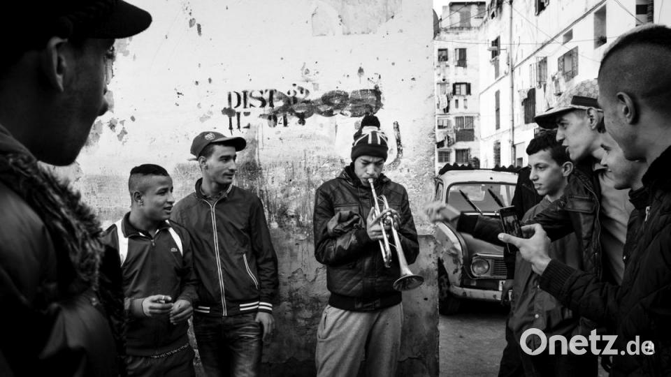 Algerien, Alger: WORLD PRESS PHOTO STORY OF THE YEAR: Ein junger Mann hat Publikum, während er im überfüllten Viertel &quot;Climat de France&quot; in Bab el-Oued mit einer Trompete experimentiert. Niemand weiß, wie man das Instrument spielt, aber es löst eine weit verbreitete Begeisterung aus. Die Serie «Kho, die Entstehung einer Revolte» über die Unruhen in Algerien des französischen Fotografen Romain Laurendeau ist &quot;Beste World Press Photo-Story des Jahres&quot;. Bild: Romain Laurendeau