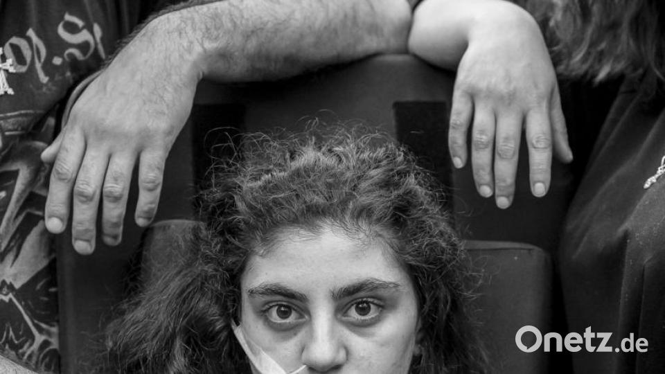 World Press Photo 2020, Kategorie &quot;PORTRAITS - FIRST PRIZE, SINGLES&quot;: Ewa, ein 15-jähriges armenisches Mädchen, das kürzlich aus einem durch das Resignationssyndrom verursachten katatonischen Zustand erwacht ist, sitzt in einem Flüchtlingsaufnahmezentrum in einem Rollstuhl, flankiert von ihren Eltern (Titel &quot;Awakening&quot;). Bild: Tomek Kaczor