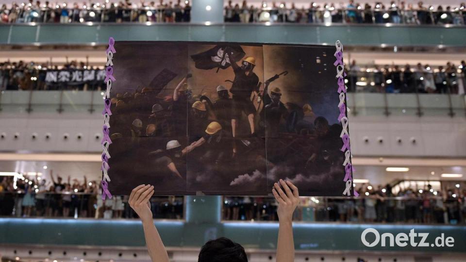 World Press Photo 2020, Kategorie &quot;GENERAL NEWS - FIRST PRIZE, STORIES&quot; (daraus das Motiv): Ein Mann hält ein Plakat in der Hand, während sich die Menschen zum Singen von &quot;Glory to Hong Kong&quot; versammelt haben - ein Protestlied, das in der Stadt als inoffizielle Hymne an Popularität gewonnen hat (Titel &quot;Hong Kong Unrest&quot;). Bild: Nicolas Asfouri