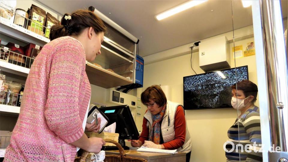 Luisa Mayer (links) kauft im mobilen Dorfladen auch für ihre älteren Verwandten ein, die jetzt wegen der Ansteckungsgefahr lieber im Haus bleiben. Zu den beiden Verkäuferinnen Olga Lamm und Jutta Dötterl (von rechts) an der Kasse bleibt sie auf Abstand. Bild: ubb