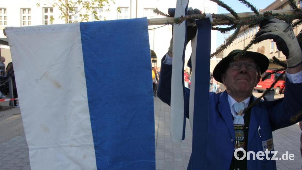 Josef Trottmann macht am Maibaum die weißblaue Fahne fest, seit 62 Jahren ist er mit dabei. Bild: kro