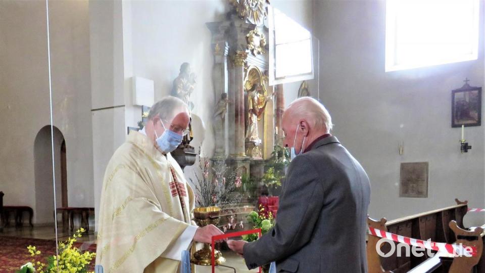 Immer nur ein Kirchengänger kommt nach vorn und nimmt durch die kleine "Durchreiche" seine Hostie entgegen. Bild: ubb