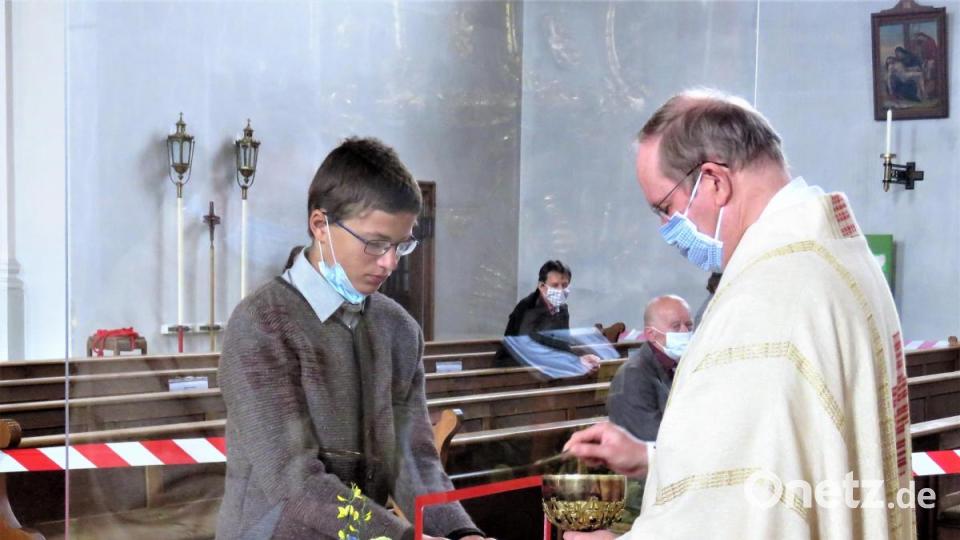 Pfarrer Markus Nees benutzt für die Hostie eine Pinzette. Das müsste er nicht, weil er Handschuhe trägt. Aber damit sei sie leichter greifbar, sagt er. Bild: ubb