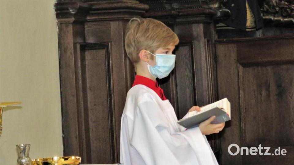 Auch die Ministranten wie dieser junge Mann in der Basilika müssen Mundschutz tragen. Bild: ubb