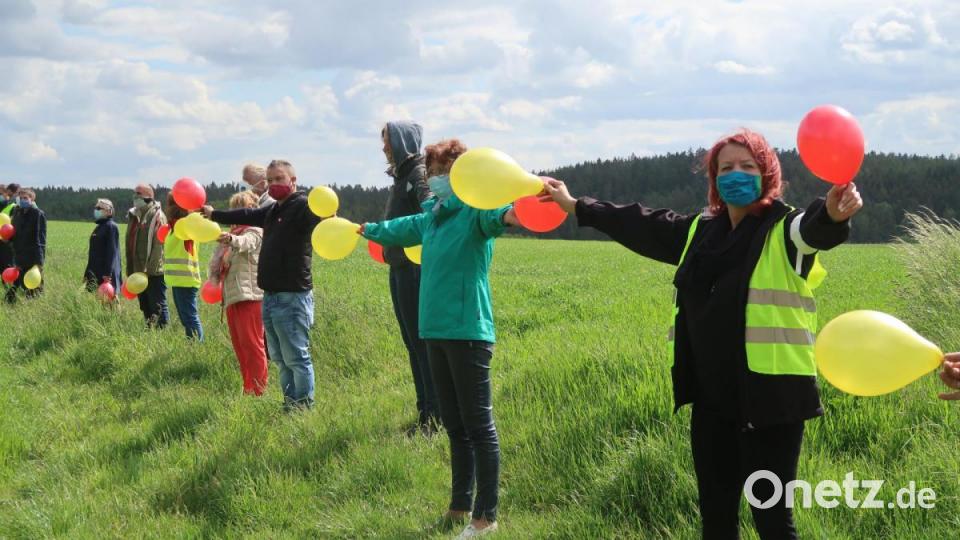 Mit bunten Luftballons demonstrieren in zwei Reihen in einem Abstand von 50 Metern Trassengegner gegen den Süd-Ost-Link. Die Formation wurde nicht ohne Grund gewählt: Sie entspricht in etwa den Ausmaßen der Trasse. Bild: Kunz