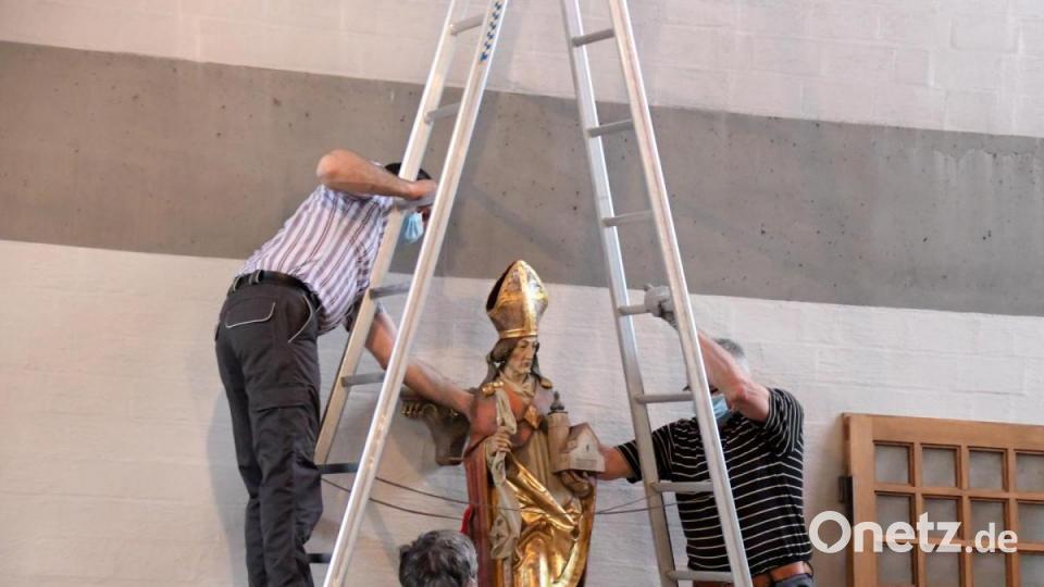 Mitglieder von Kirchenverwaltung und Pfarrgemeinderat haben mit angepackt, um Kreuzwegstationen und Heiligenfiguren an den Wänden abzumontieren. Bild: Agnes Jonas
