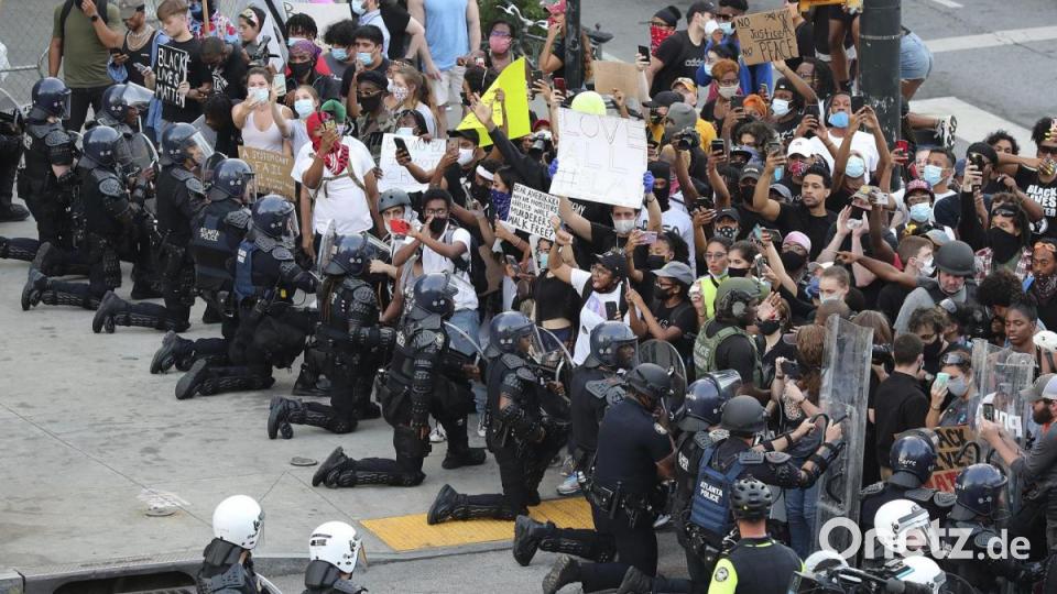 Polizisten knien in Atlanta aus Solidarität vor Demonstranten nieder. Bild: Curtis Compton/Atlanta Journal-Constitution/AP/dpa