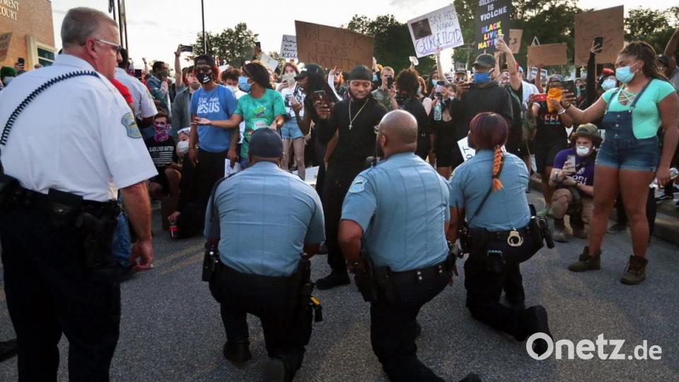 Polizeibeamte knien in St. Louis während einer Demonstration vor den Protestierenden. Bild: Robert Cohen/St. Louis Post-Dispatch/AP/dpa