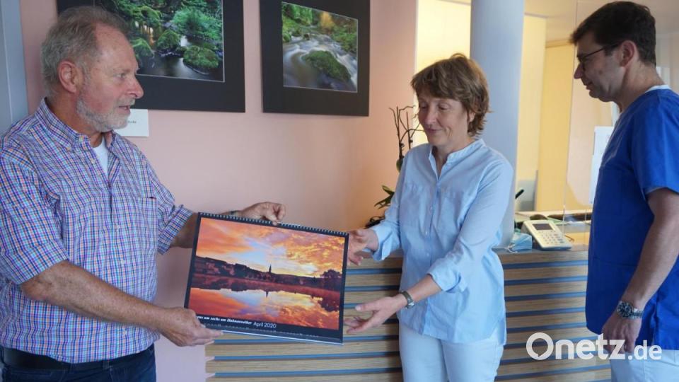 Als Dankeschön überreicht Siegi Filipp seinen Fotojahreskalender an Carmen (Mitte) und Friedrich Feldmeier (rechts). Im Hintergrund zwei Aufnahmen von der Ascha im Rosenthal Bild: eib