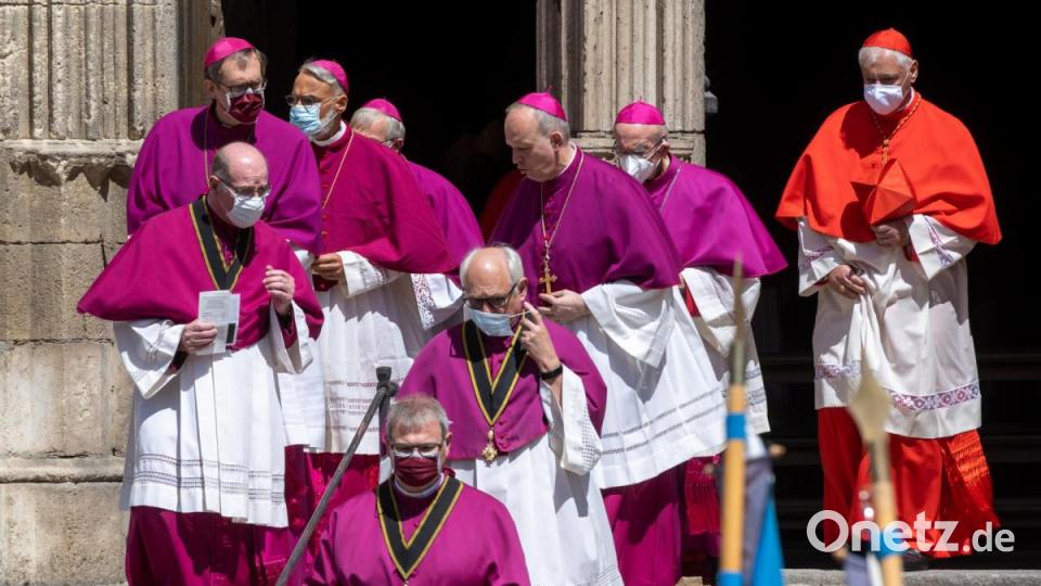 Geistliche verlassen nach der Trauerfeier für Georg Ratzinger den Dom mit Gesichtsmasken. Bild: Armin Weigel/dpa