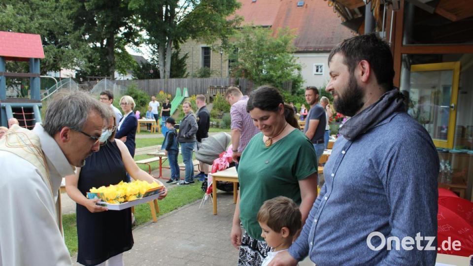 Von Tisch zu Tisch ging Pfarrer Besold (links), um die Kinder und Eltern zu segnen. Stellvertretend legten die Eltern ihre Hände auf die Schultern ihrer Kinder. Bild: fks